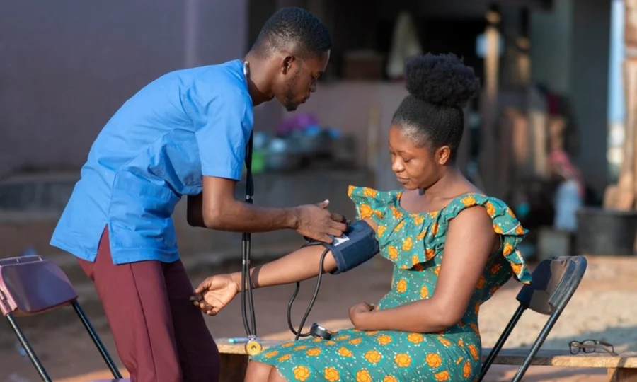 A health worker checking blood pressure in a community setting