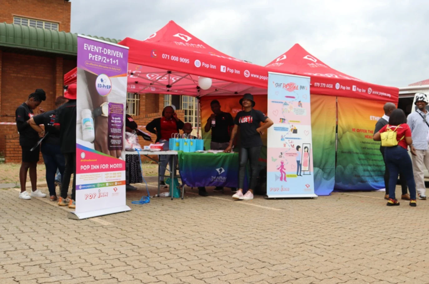 Pop Inn outreach stand with red tents and information banners